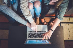 A family gathers around a laptop for a virtual open day