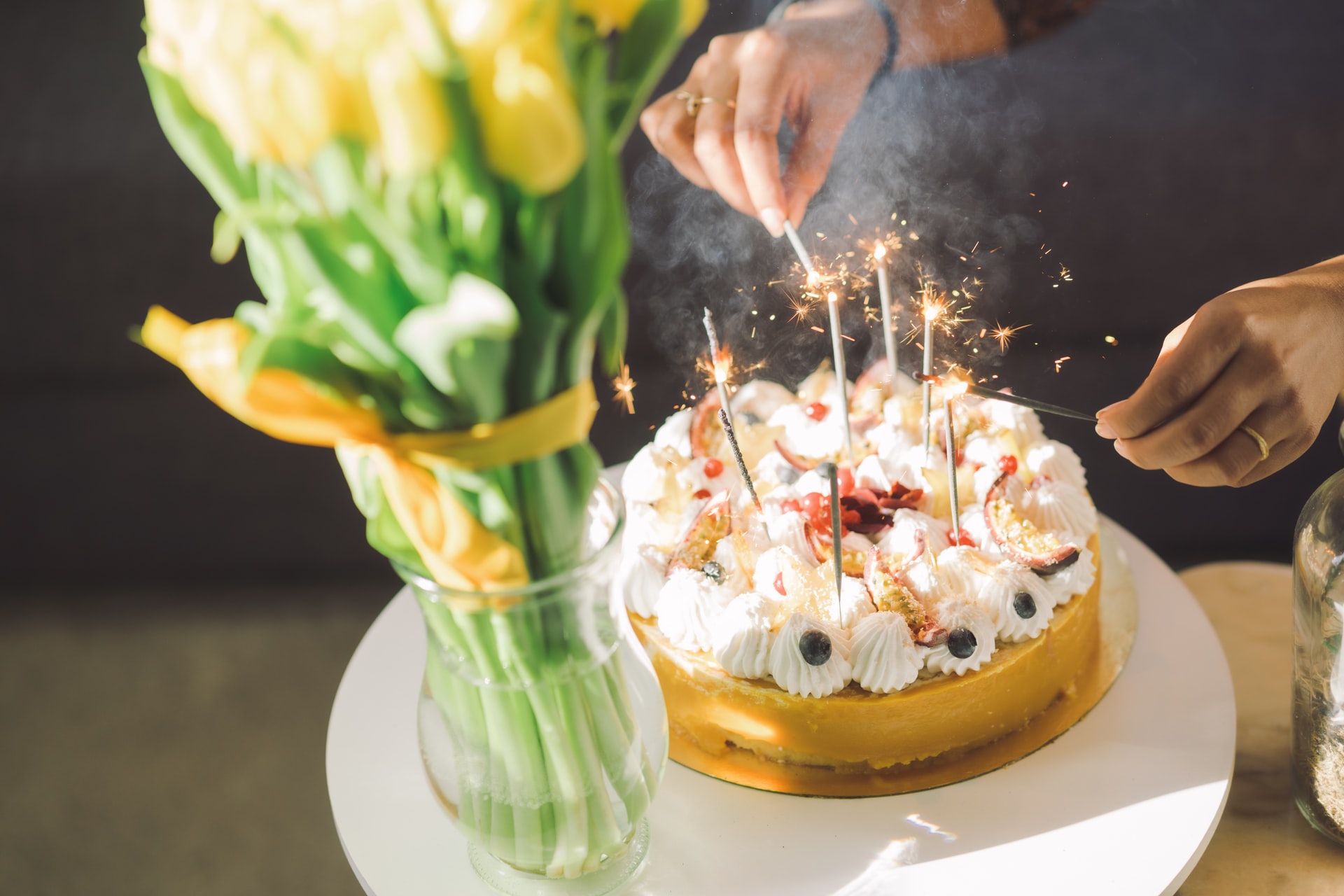 A woman lights candles on a birthday cake